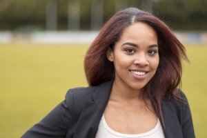 Close up Charming Young Afro-American Businesswoman at the Green Field, Looking at the Camera with Toothy Smile.