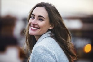 Close-up portrait of beautiful caucasian woman with charming smile walking outdoors