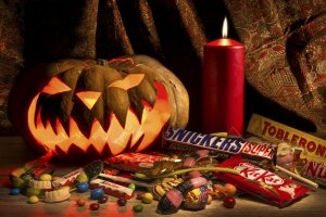 Moscow, Russian Federation – December 24, 2015. Halloween pumpkin and many candy bars. Spooky Jack-o'-lantern