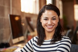 Portrait Of Female Designer Working At Desk In Modern Office