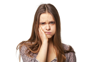 Portrait of young beautiful woman with toothache holding hand on her chick. Isolated on white.