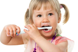 Close up portrait of little girl brushing teeth.Isolated on white background.